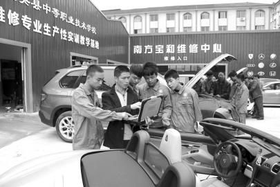大英縣中等職業學校通過“引企入?！?，將企業維修中心建到了校園內，圖為企業專業技師向學生講解高檔轎車的保養維修技巧。